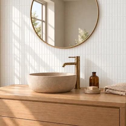 Mur de salle de bain en carrelage adhésif blanc brillant à baguettes, vasque à poser et miroir rond