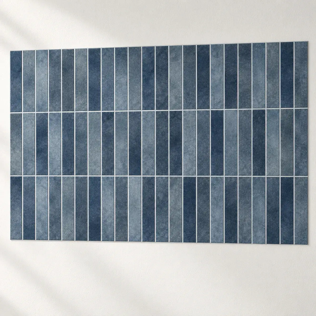 Carreaux adhésifs Oceana bleu indigo assemblés sur un mur blanc, joints alignés d'un carreau à l'autre