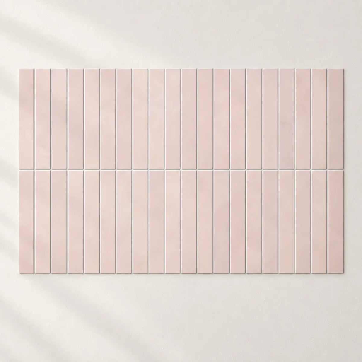 Carreaux adhésifs Aurora rose poudré assemblés sur un mur blanc, joints alignés d'un carreau à l'autre