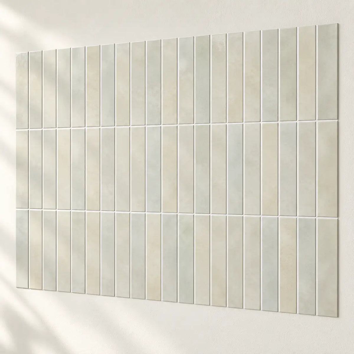 Carreaux adhésifs Opalia vert sauge assemblés sur un mur blanc, joints alignés d'un carreau à l'autre