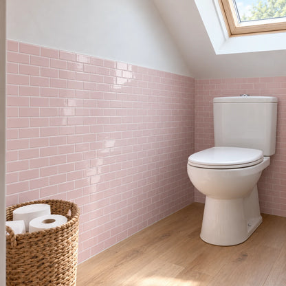 Toilettes sous les combles avec carrelage adhésif métro rose poudré, WC à réservoir et fenêtre de toit