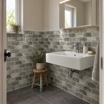 Petite salle de bain avec lavabo suspendu blanc et carrelage adhésif mini métro gris pierre sur deux murs