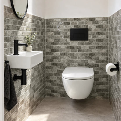 Toilettes avec WC suspendu, lave-mains et carrelage adhésif mini métro gris pierre, plaque de commande noire