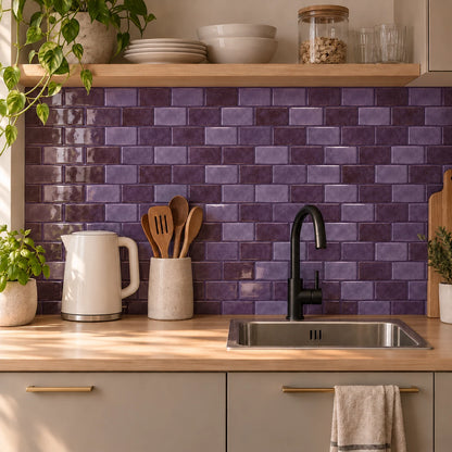 Kitchenette aux façades grège et plan en bouleau avec crédence en carrelage adhésif mini métro violet prune sous une étagère