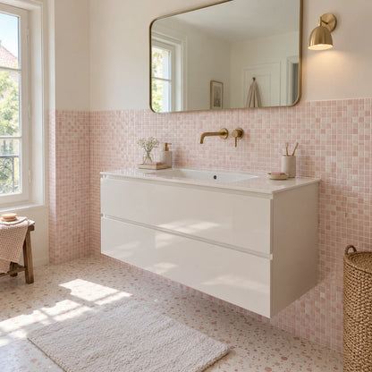 Salle de bain avec carrelage mural adhésif mosaïque rose poudré, meuble vasque blanc laqué et grand miroir aux angles arrondis