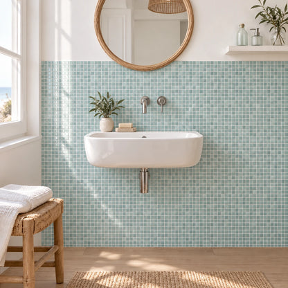 Salle de bain avec carrelage mural adhésif mosaïque vert d'eau, vasque suspendue blanche et miroir rond en rotin